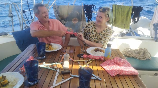 Two people on a yacht pulling a pink cracker during Christmas