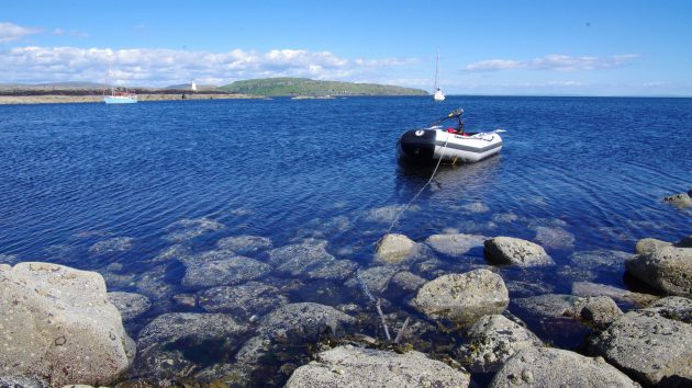 A dinghy flowing in a rocky harbour