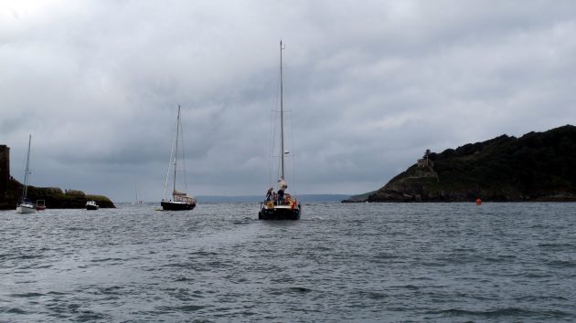 Two yachts anchored in a bay with grey skies