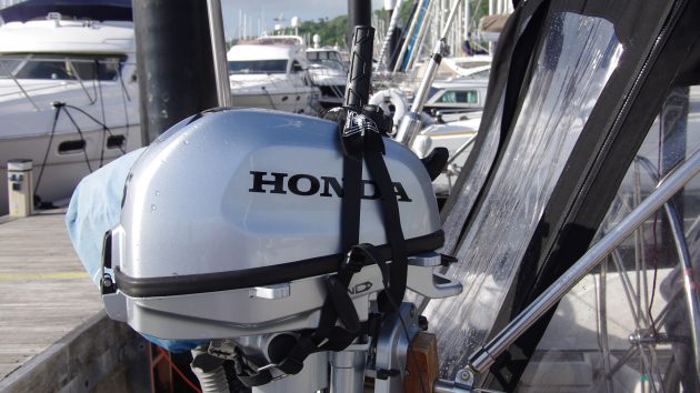 A dinghy outboard being lowered in a harness